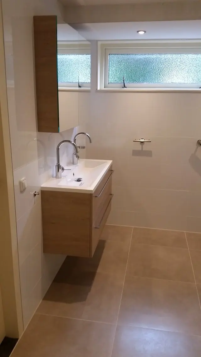 Gerenoveerde badkamer in Mildam met een wastafel met twee kranen