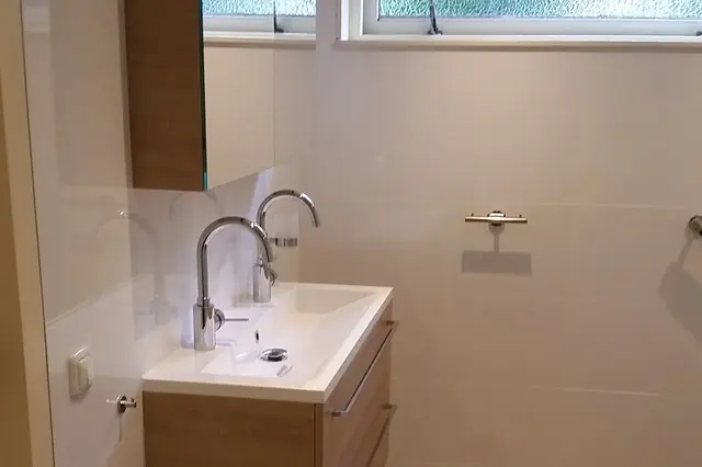 Gerenoveerde badkamer in Mildam met een wastafel met twee kranen