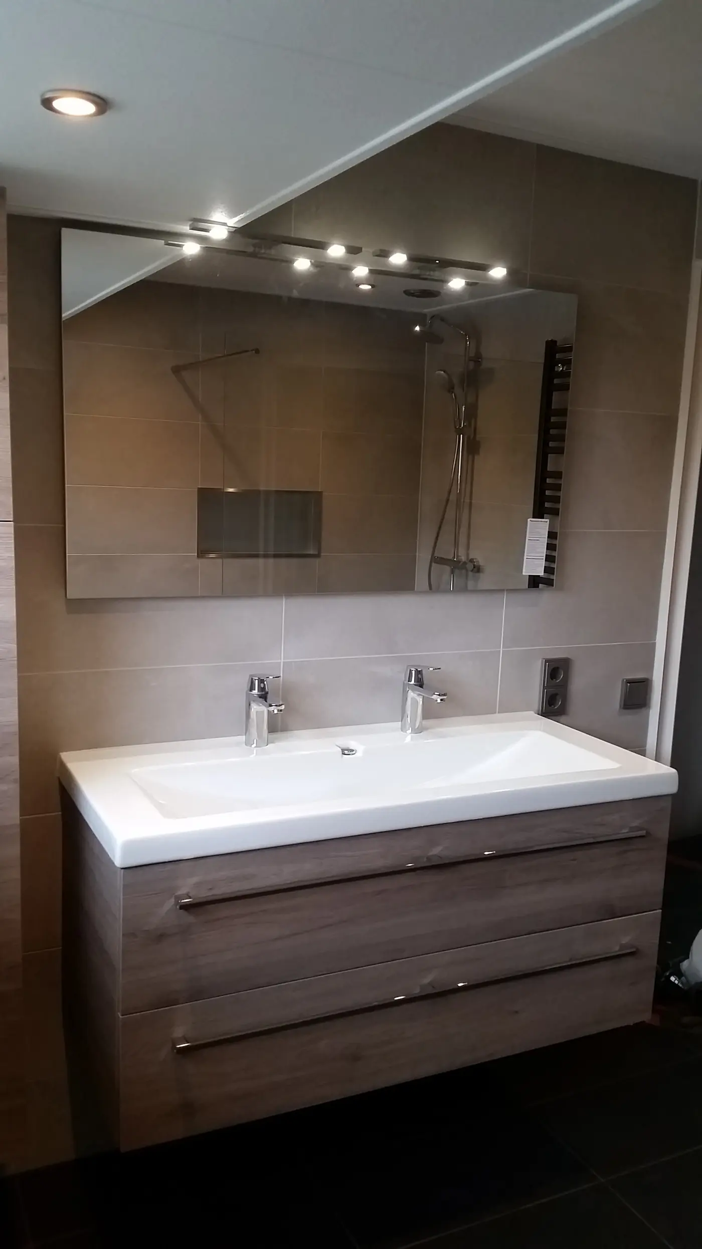 Gerenoveerde badkamer in Oranjewoud met wastafelmeubel, grote spiegel en designradiator