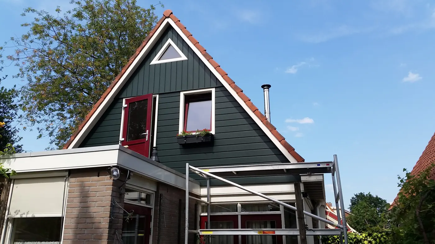 Opgeleverde uitbreiding van de eerste verdieping in Heerenveen, met donkergroene gevelbekleding en een rode deur, foto 2